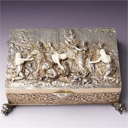 German 800 standard silver gilt and ivory mounted box, the hinged cover embossed and chased with an allegorical feasting scene, the sides with floral decoration, on four cast lion feet 21cm x 16cm x 8cm Maker Ludwig Neresheimer, Hanau circa 1900 This item has been registered for sale under Section 10 of the APHA Ivory Act