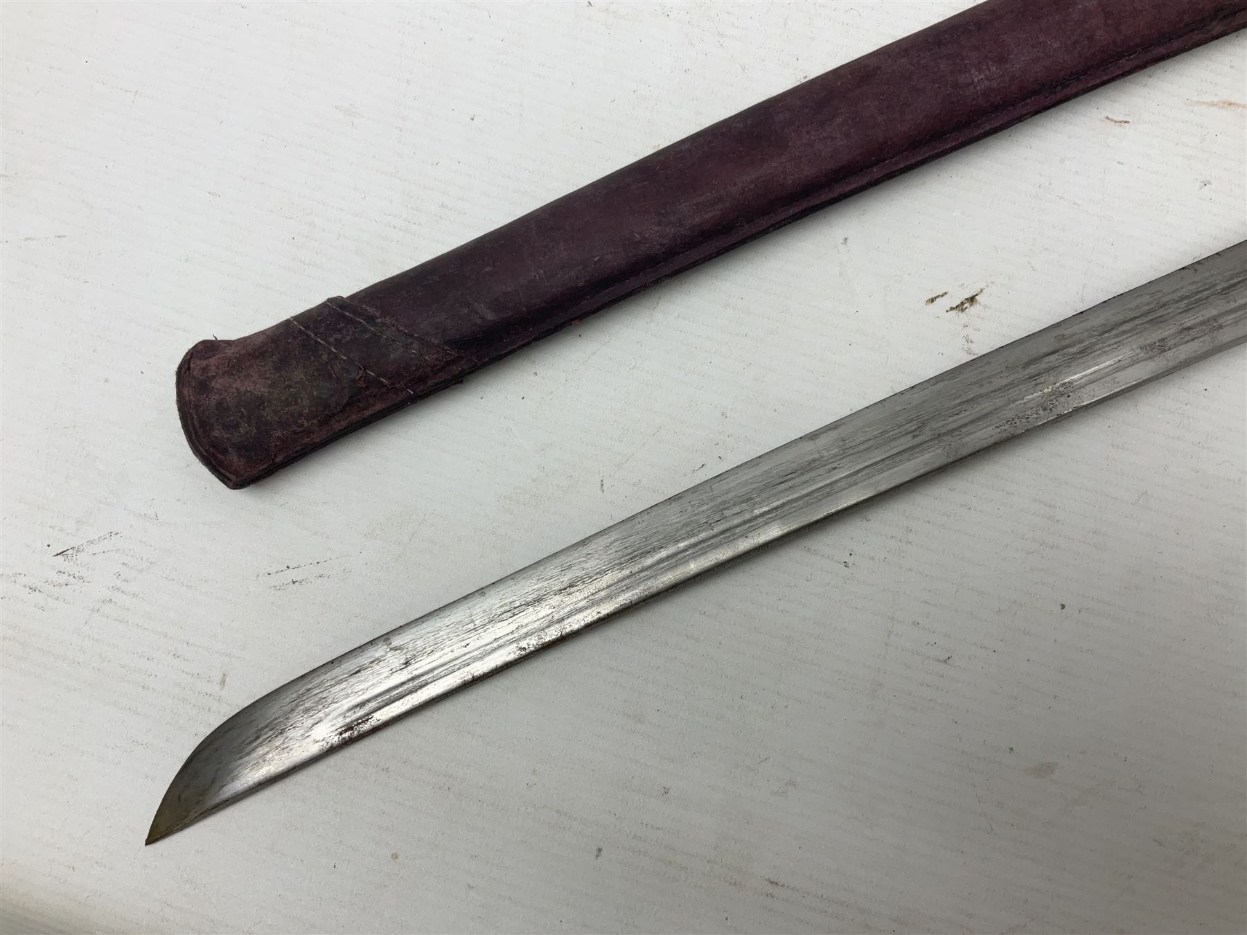 Copy of a WWII Japanese NCO sword, the 65cm slightly curving blade stamped with pseudo Japanese characters and cast brass simulated cord bound grip; in officer's leather bound field scabbard L97cm overall