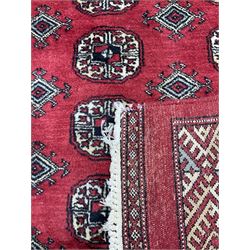 Turkmen Tekke Bokhara rug, red ground and decorated with Gul motifs, repeating multi-band border, signed on corners 