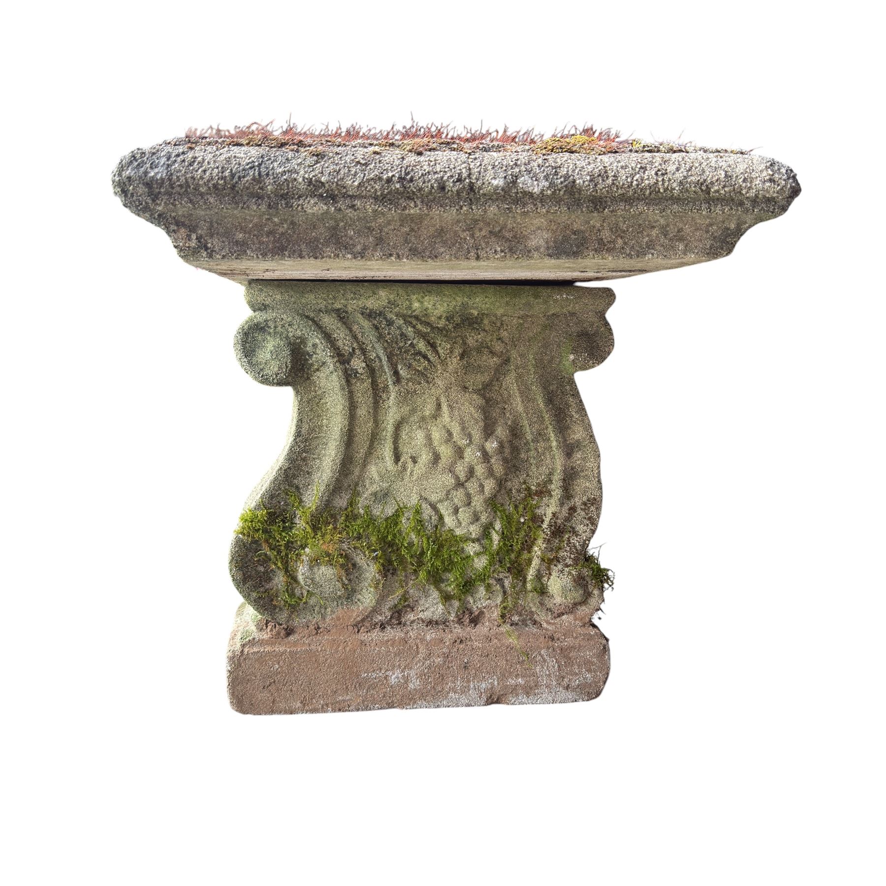 Weathered cast stone three piece bench, the rectangular seat with moulded edge, raised on Neoclassical style end supports with S-scrolls and fruiting grapevines, on rectangular bases