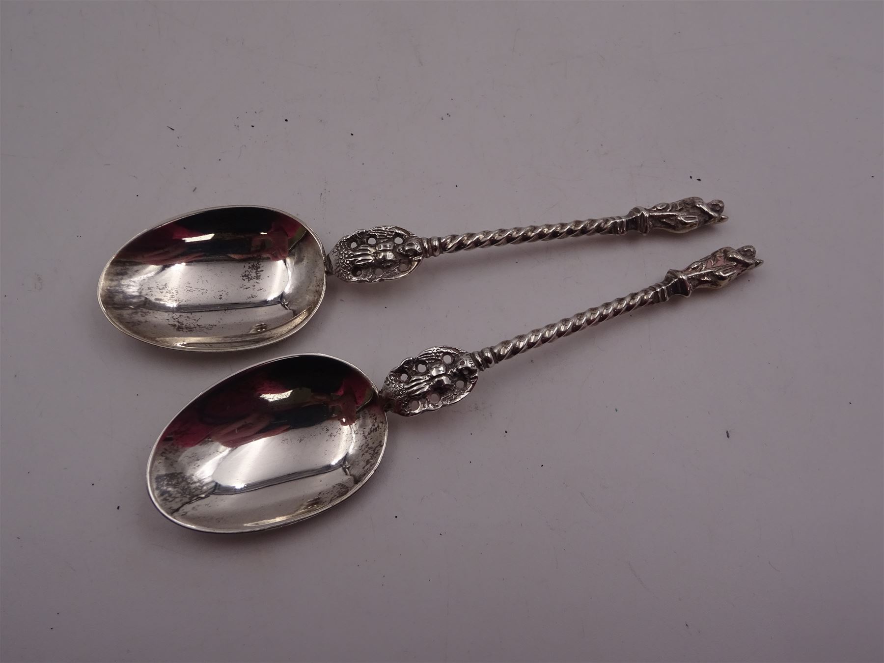 Group of silver, comprising 1930s pepper, of typical plain form, hallmarked Harrods Ltd, London 1938, together with an Edwardian vesta case, with engraved foliate decoration and monogramed rose gold shield cartouche, hallmarked G Loveridge & Co, Birmingham 1901, a pair of Victorian apostle top spoons, with pierced figural twisted stems, hallmarked Martin, Hall & Co, Sheffield 1864 and a modern silver candle snuffer with turned wooden handle, hallmarked R&D, Sheffield 2004