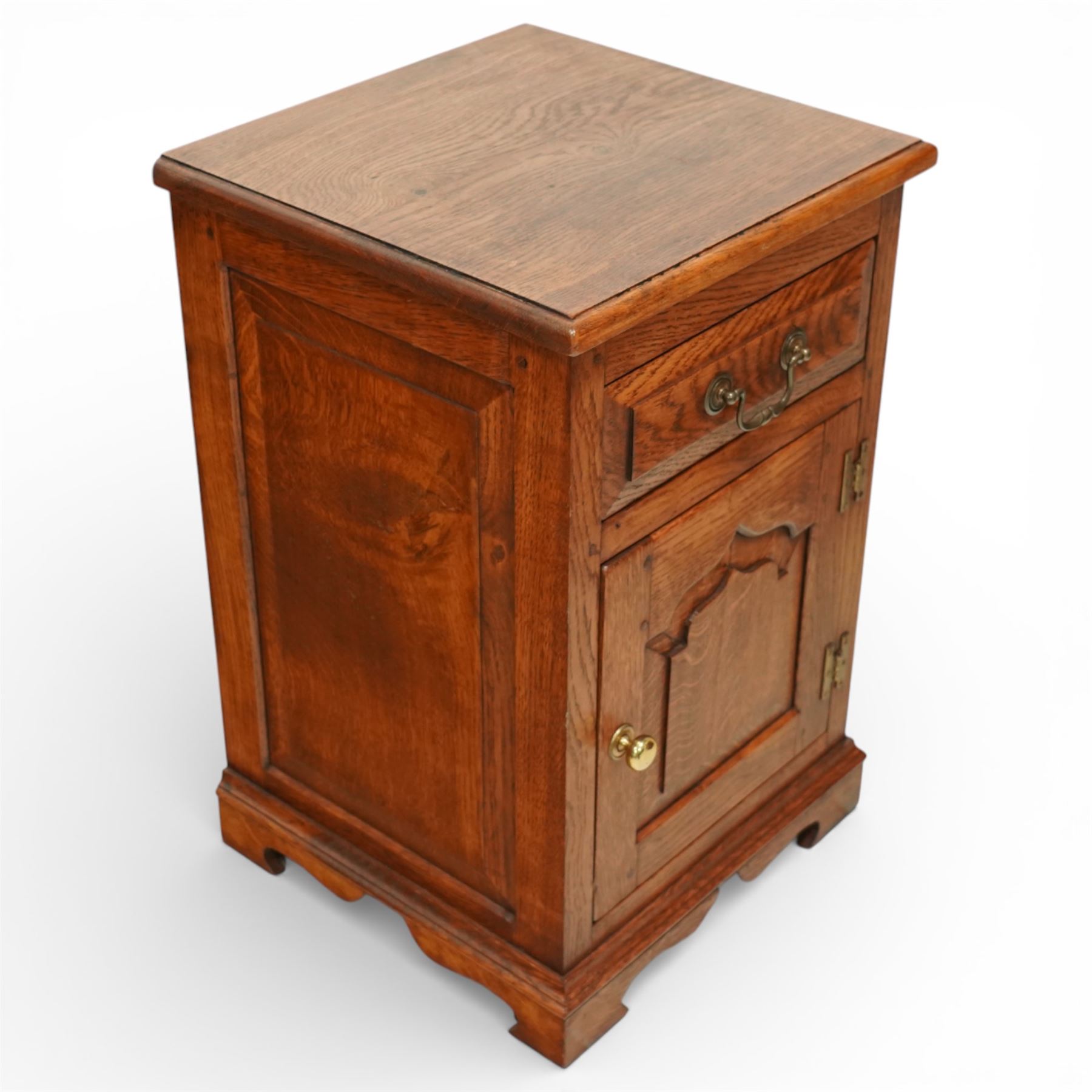 20th century pair of oak bed side cabinets, in the manner of Titchmarsh & Goodwin, plain rectangular tops over drawers fitted with brass handles and cupboard doors with carved arched panels, panelled sides and backs, raised on shaped bracket feet