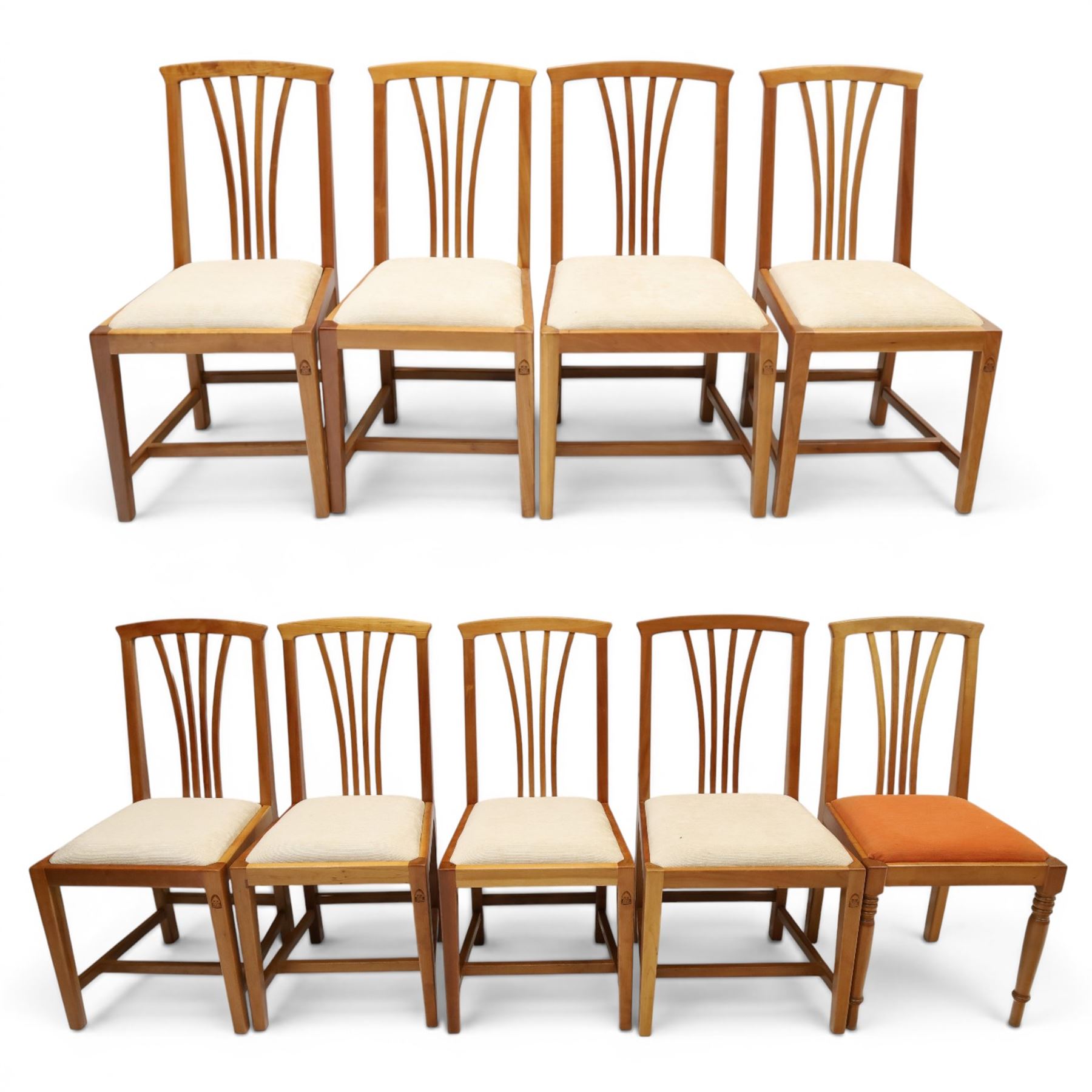 Knightman - set of nine cherrywood dining chairs, with fan splat backs and upholstered seats, raised on square legs joined by stretchers, comprising chairs of slight differing widths and one chair with turned front legs and orange upholstery and no Knight carving, the rest with recessed carved knight trademark, by Horace Knight of Old Mill Furniture, Balk near Thirsk 