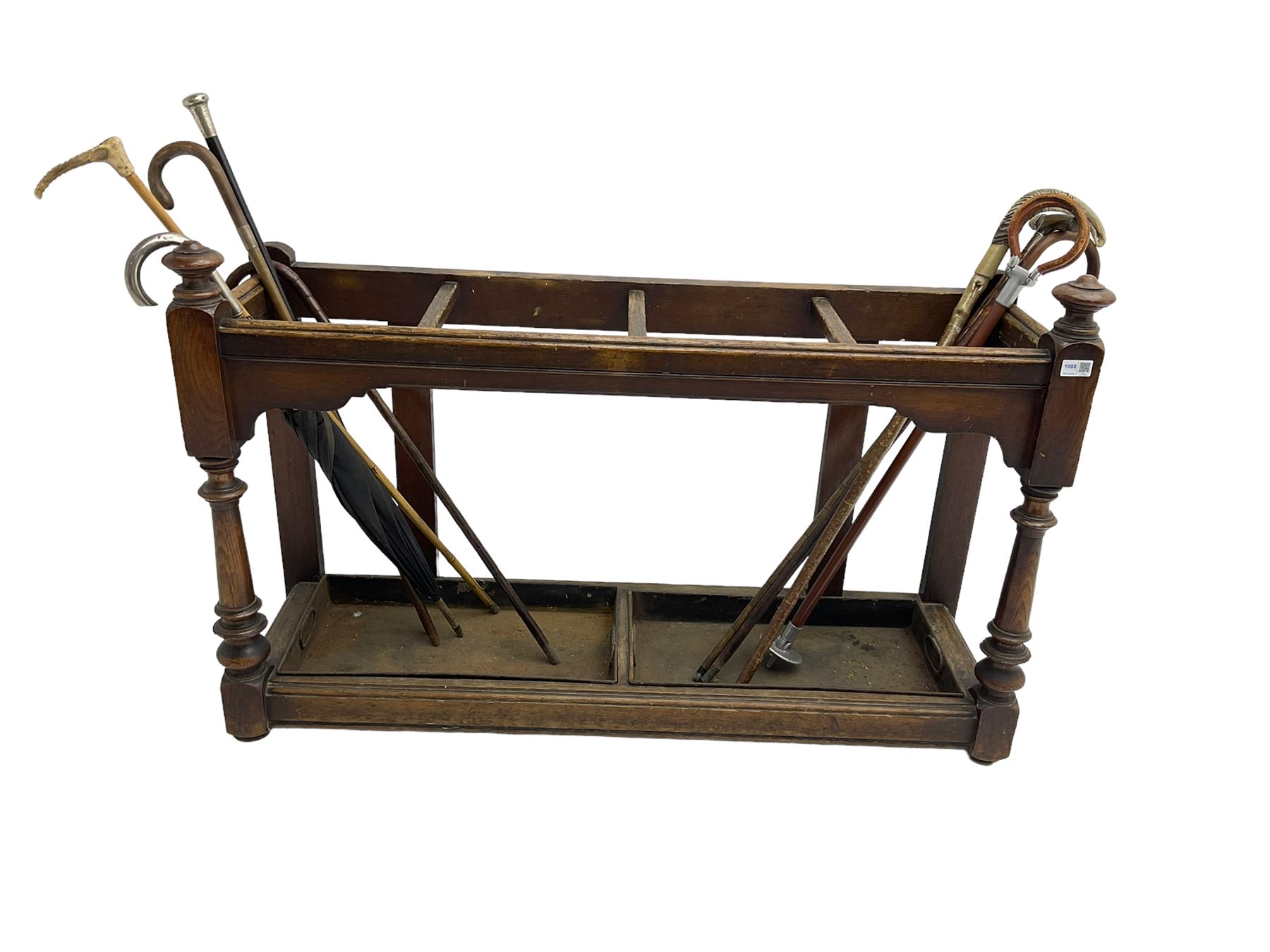 Edwardian oak hallway stick and umbrella stand, four divisions on turned supports, with metal tray liners and various sticks