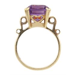 Gold single stone amethyst ring with scroll design shoulders and heart gallery, stamped 9ct