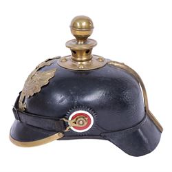 WWI Prussian EM M1895 artillery Pickelhaube, circa 1895, the black leather skull with brass ball finial, brass eagle helmet plate and leather chin strap, one side with a black cockade, the other black and red