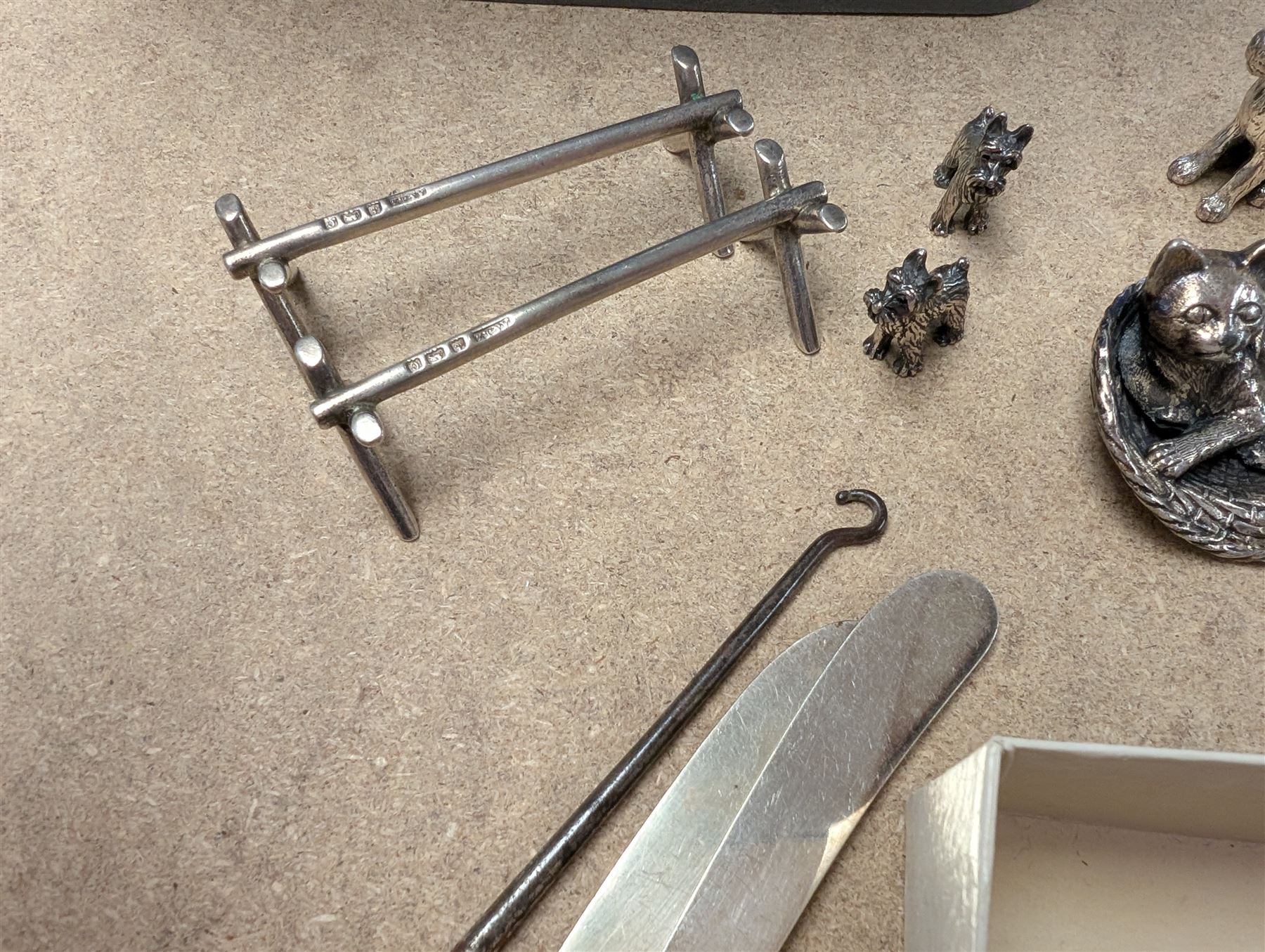 Pair of silver knife rests, two silver handled butter knives and a silver handled button hook, all hallmarked, together with a silver onyx pendant and ring, white metal figures and coins etc 