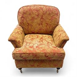Duresta - Contemporary pair of upholstered armchairs, in red and gold damask style fabric, each with sprung seat and removable cushion back, rolled arms, on turned front supports with brass castors, square back legs 