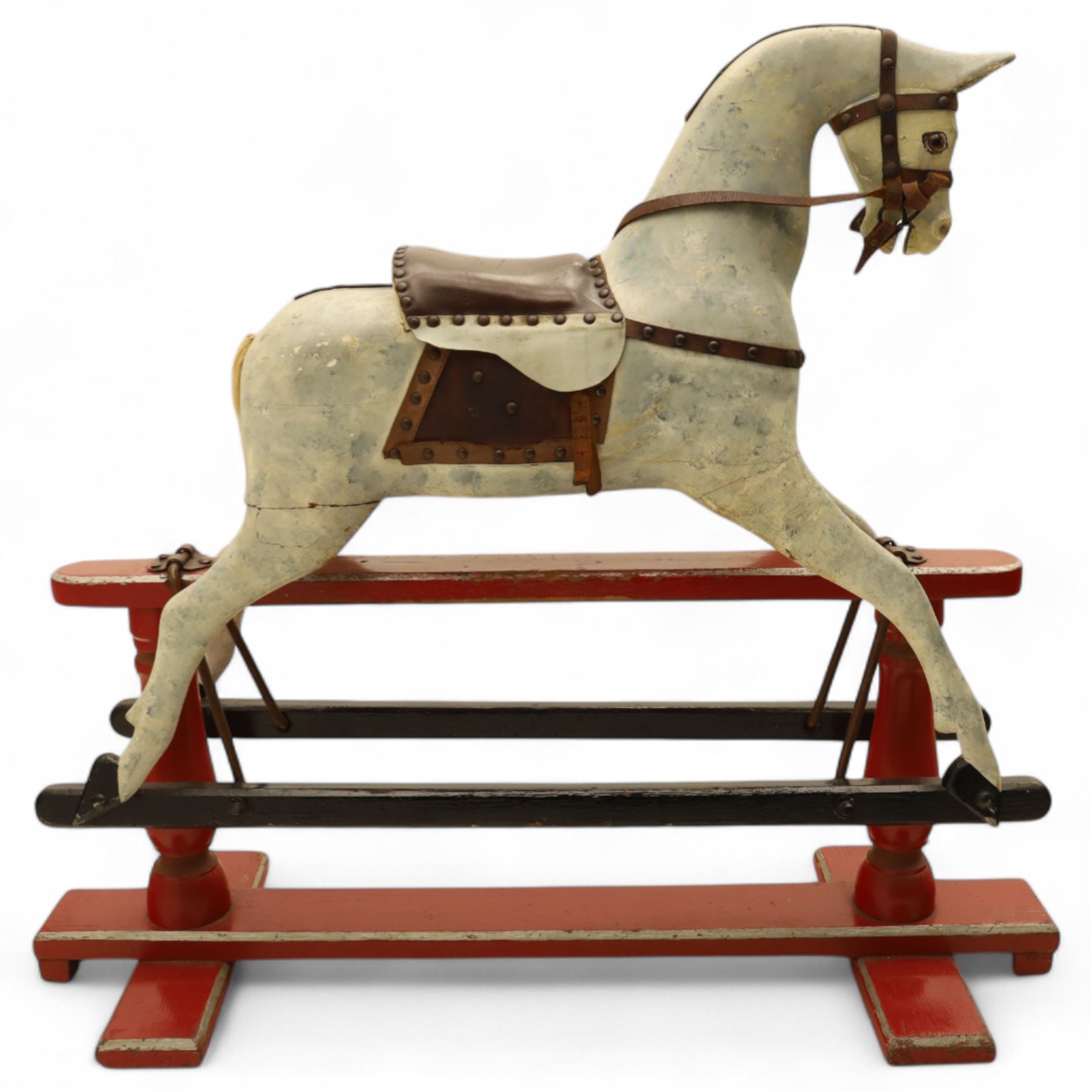 20th century carved and painted rocking horse, with original dappled paint finish, studded leather saddle and reins, on later red and black swing frame