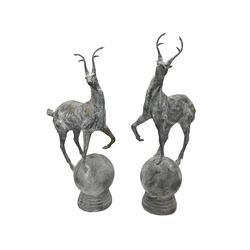 Pair of cast iron garden stag finials atop a sphere base, in rustic finish