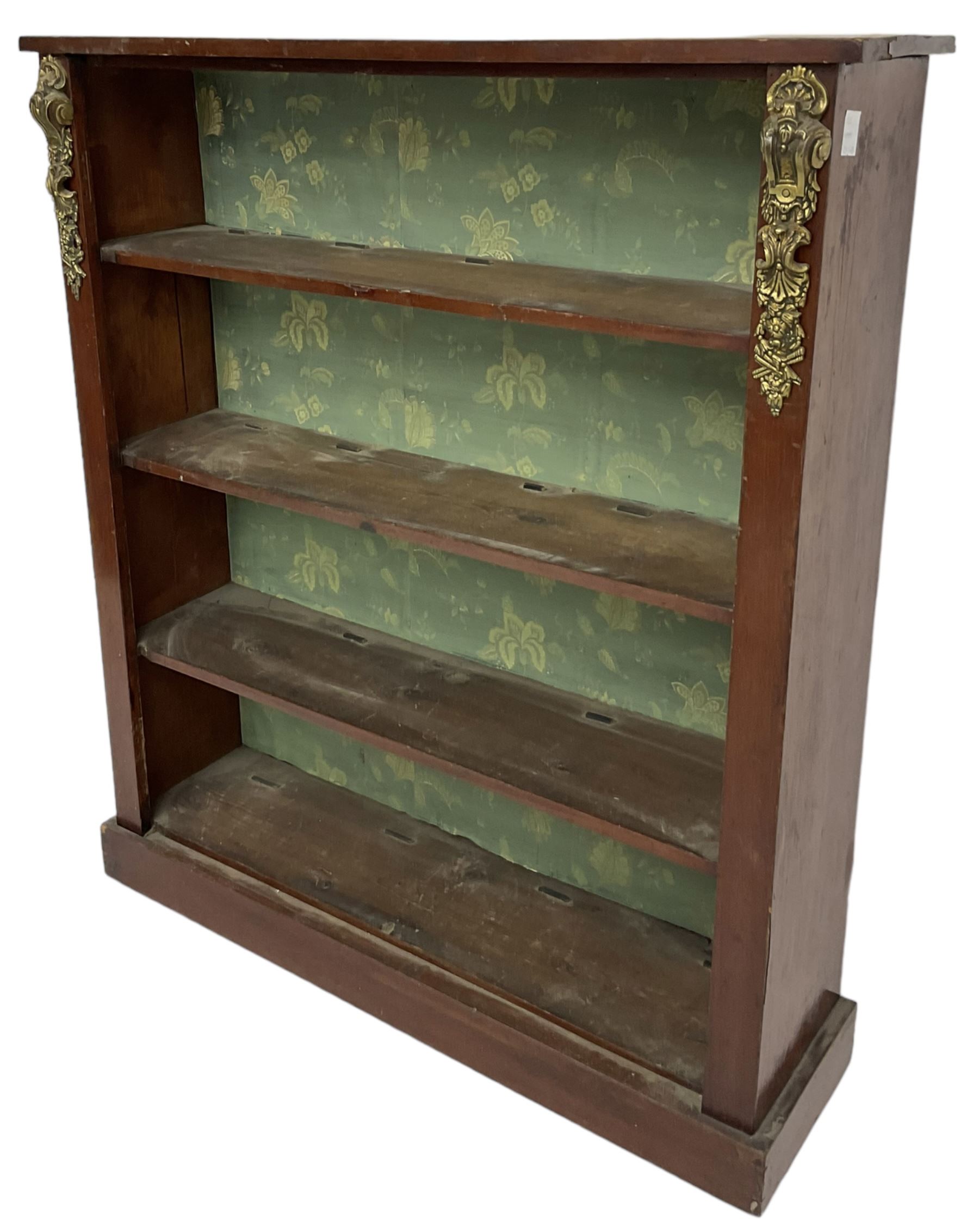 Early 20th century mahogany open bookcase, fitted with three shelves on plinth base, decorated with foliate patterned gilt metal mounts