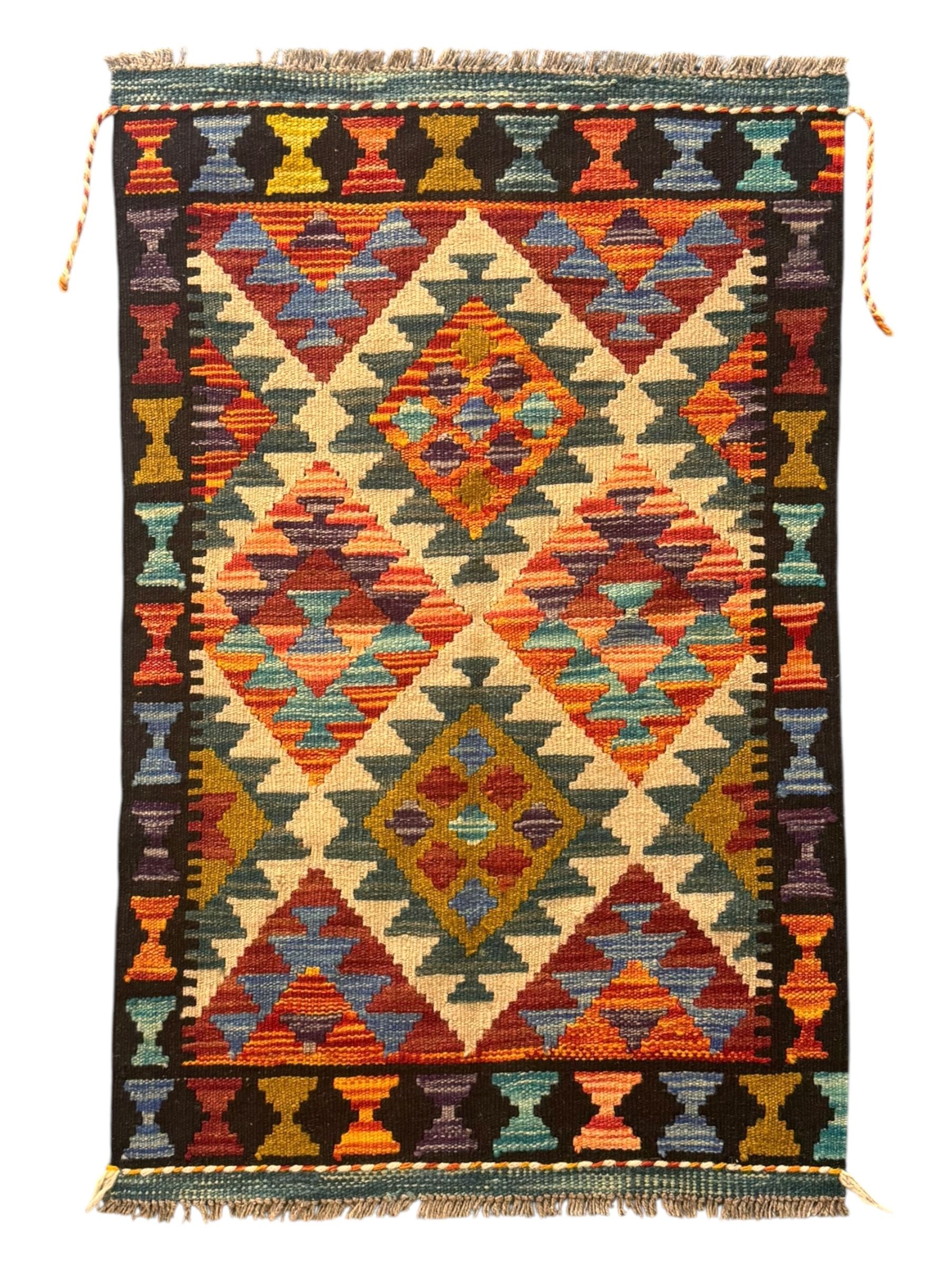 Afghan Maimana flatweave Kilim rug, the field decorated with multi-coloured diamond motifs in a stepped formation, framed by a bold hourglass border,