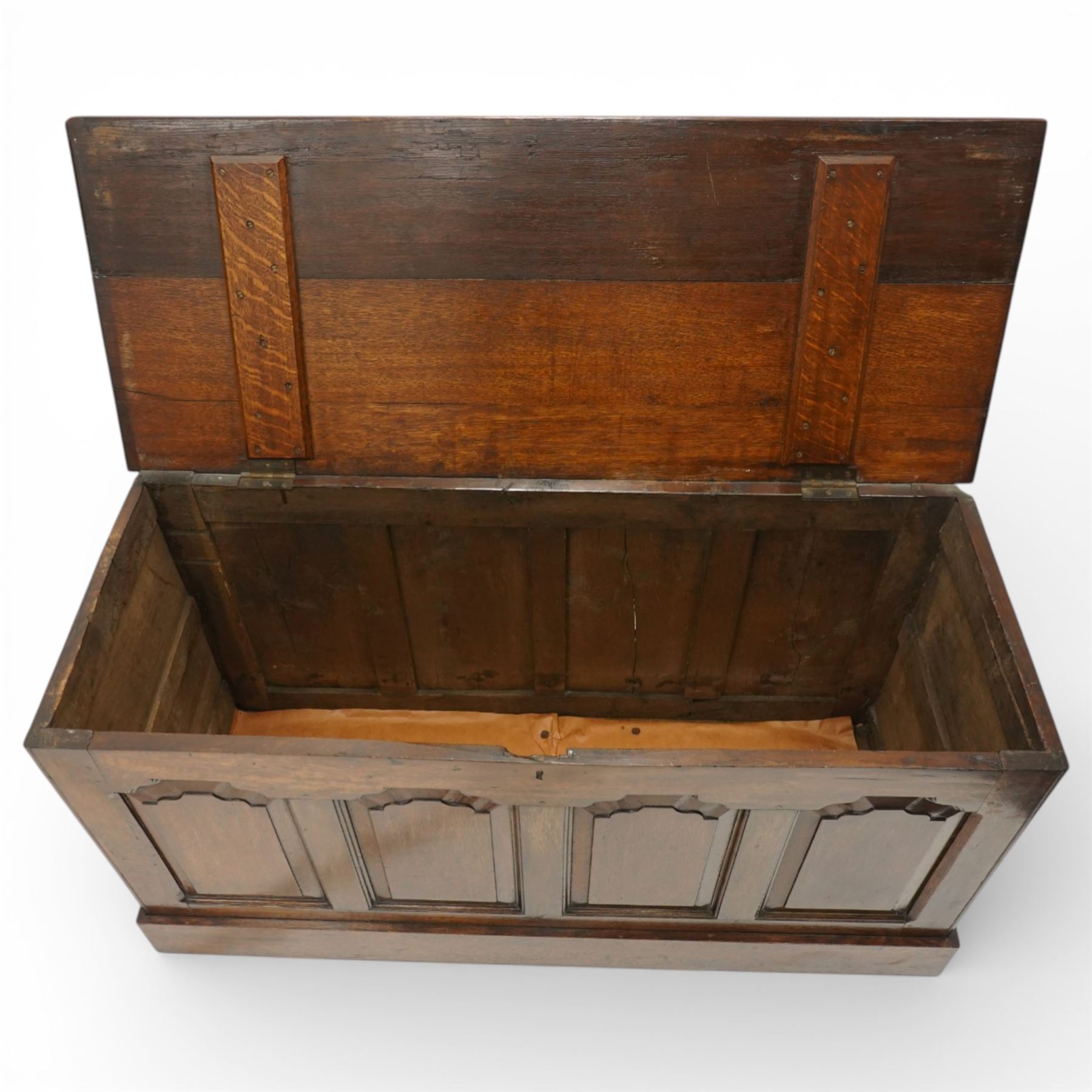 Late 19th century Gothic Revival oak coffer, the plain hinged top over four fielded arch moulded panels, the sides panelled and raised on a block plinth, the interior with vertical boarding and later iron hinges