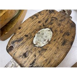 Three ship pulleys comprising wooden block double with swivel eye marked 'wooden block 240mm double rope: 22mm',  wooden block double with upset shackle and wooden block with stiff swivel hook, largest example L50cm