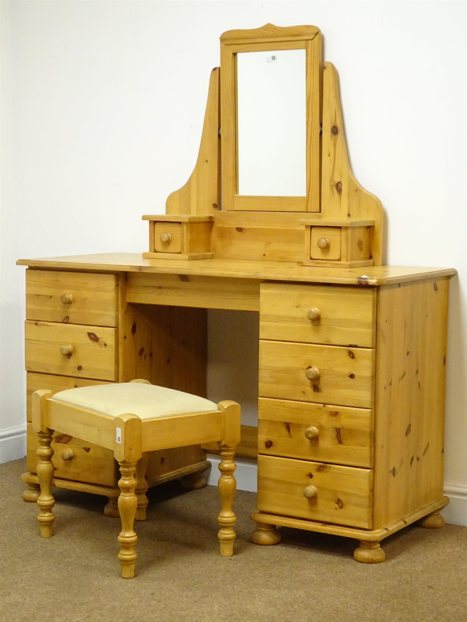 Pine kneehole dressing table with eight drawers on bun feet (W127c