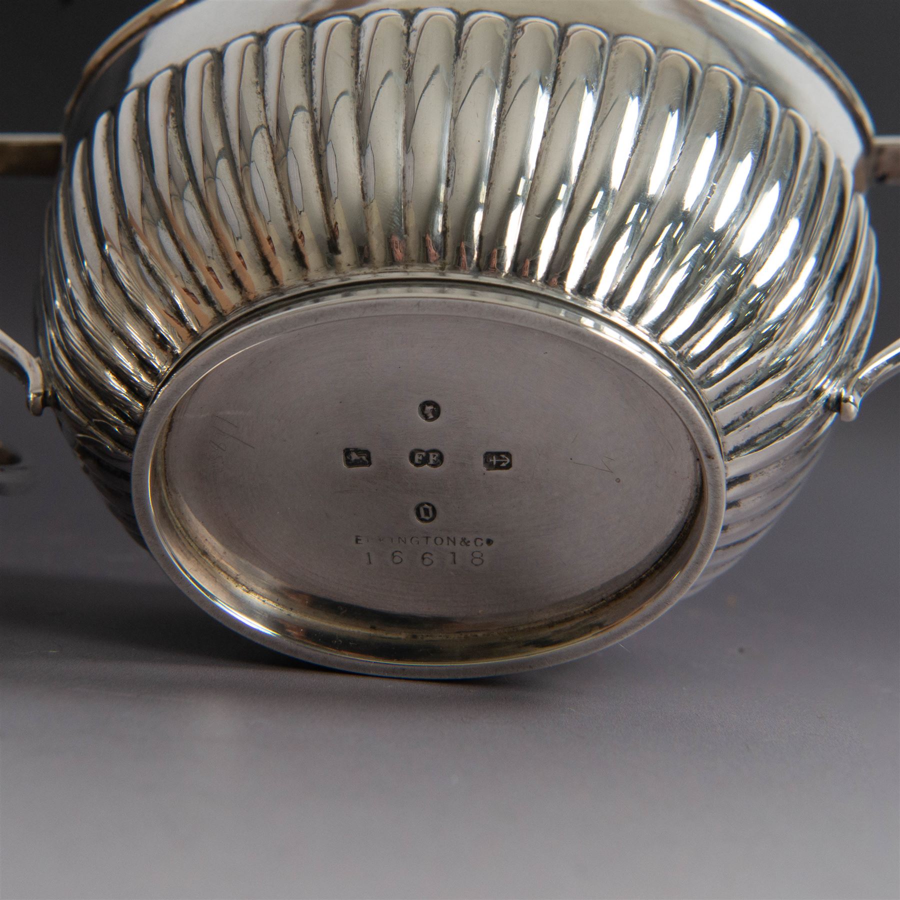 Victorian silver four piece tea service, comprising coffee pot, teapot, twin handled open sucrier and milk jug, all of oval part fluted form and engraved with initial to body, the coffee pot on oval stepped foot, coffee pot and teapot with ebonised wooden finials, hallmarked Elkington & Co, Birmingham 1888