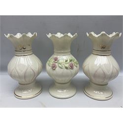 Five late 19th/early 20th century and later Belleek vases, comprising pair of Lotus Blossom examples, shamrock tree trunk vase, twin handled shamrock vase and a baluster form vase decorated with applied roses, all with printed marks beneath, tallest H16cm