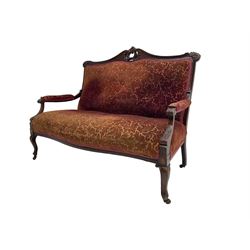 Late 19th century walnut framed settee, the shaped cresting rail with carved and pierced cartouche pediment, leaf carved ears, upholstered in scrolling foliate patterned fabric, acanthus carved arm supports, on cabriole supports with castors