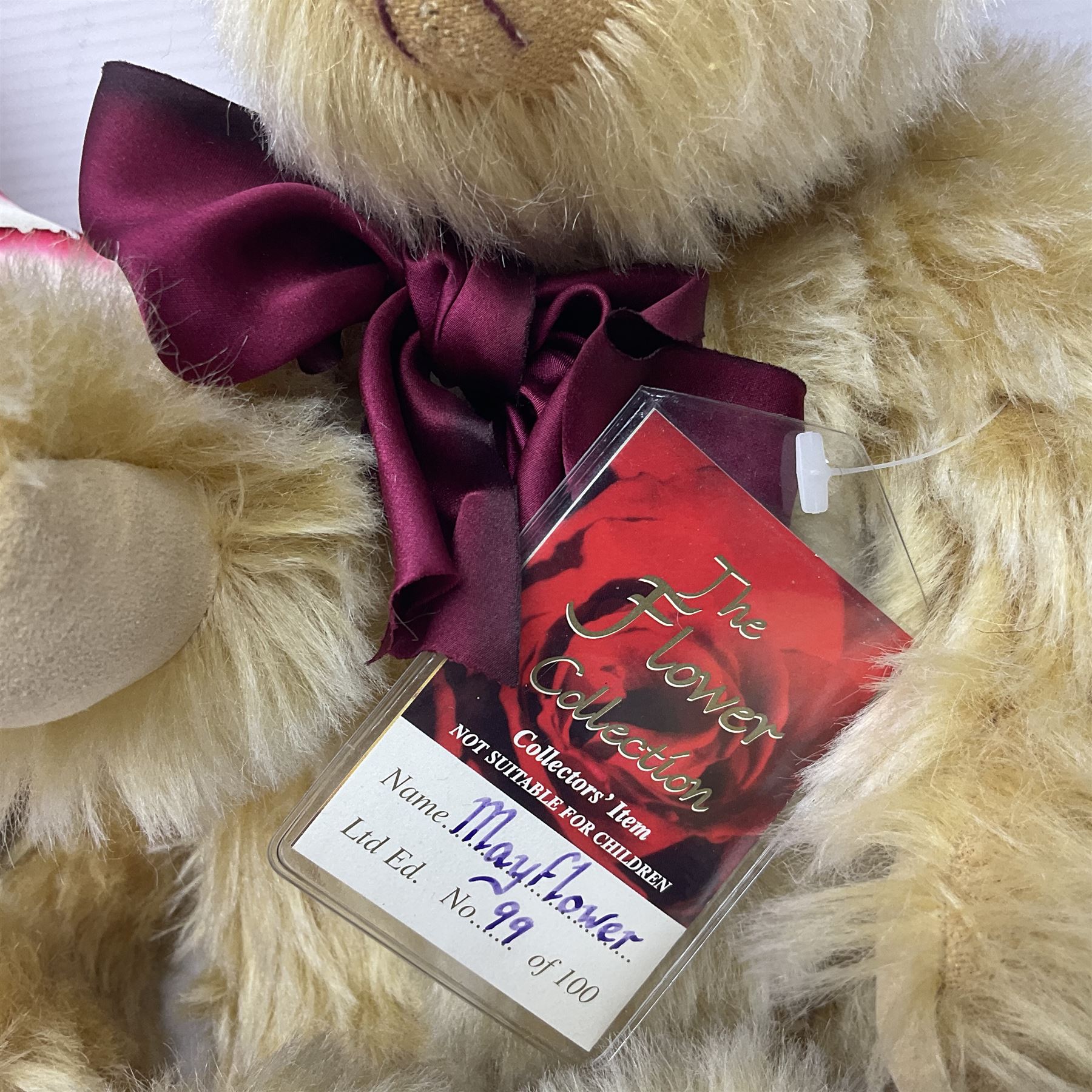 The Cotswold Bear Company - two teddy bears from ‘The Flower Collection’ comprising ‘Mayflower’ no.99/100, blonde mohair with dark pink flower crown and bow, H33cm; ‘Phoenix’ no. 99/100, blonde mohair with white and red rose flower crown and bow, H28cm; both with original labels and purchase receipt (2)