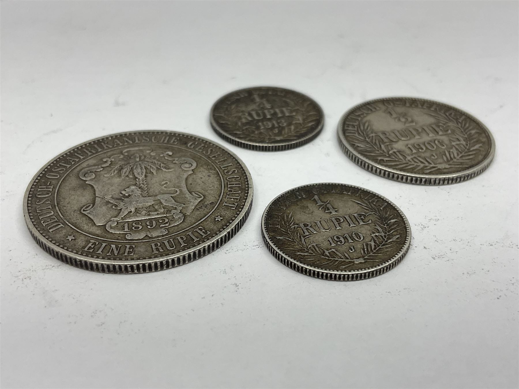 German East Africa 1892 one rupie, 1906 half rupie, and two quarter rupie coins dated 1910, 1913