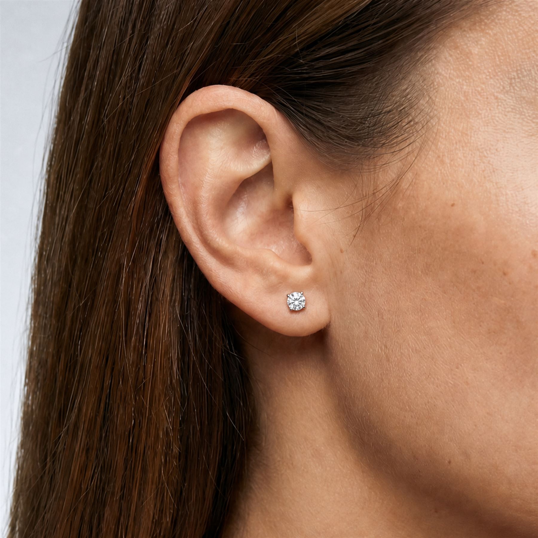 Pair of 18ct white gold diamond earrings, each stud four claw set with a single round brilliant cut diamond, stamped 750, total diamond weight approx 1.05 carat