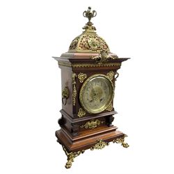 Lenzkirch - Edwardian German 8-day  mantle clock in an oak case with brass mounts and a pierced dome pediment with finial, silvered dial with Arabic numerals, gilt hands and dial centre, rack striking movement, striking the hours and half-hours on a coiled gong. With pendulum and key.