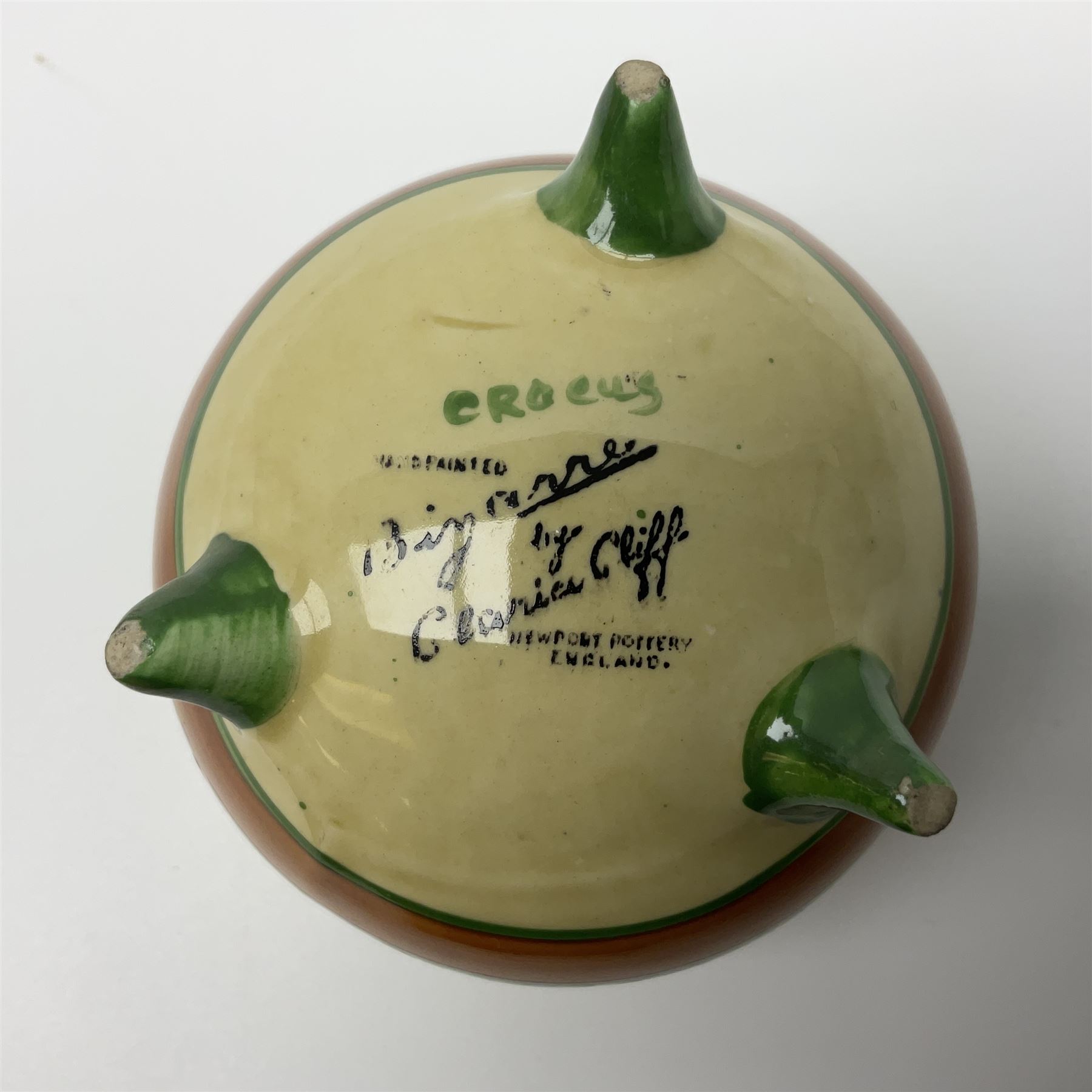 Clarice Cliff Bizarre for Newport Pottery, small bowl in the form of cauldron painted in the Crocus pattern, bordered by brown and yellow banding, with angular handles and raised upon three peg feet, with green printed mark and painted CROCUS beneath, circa 1929, H7cm