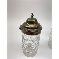 A group of Victorian glass condiment bottles, to include a set of four bottles and jar with cut decoration, one bottle with pierced silver domed top, another bottle with silver gilt spoon top, and jar with silver domed hinged cover, all hallmarked Robert Harper, London 1868. (8). 