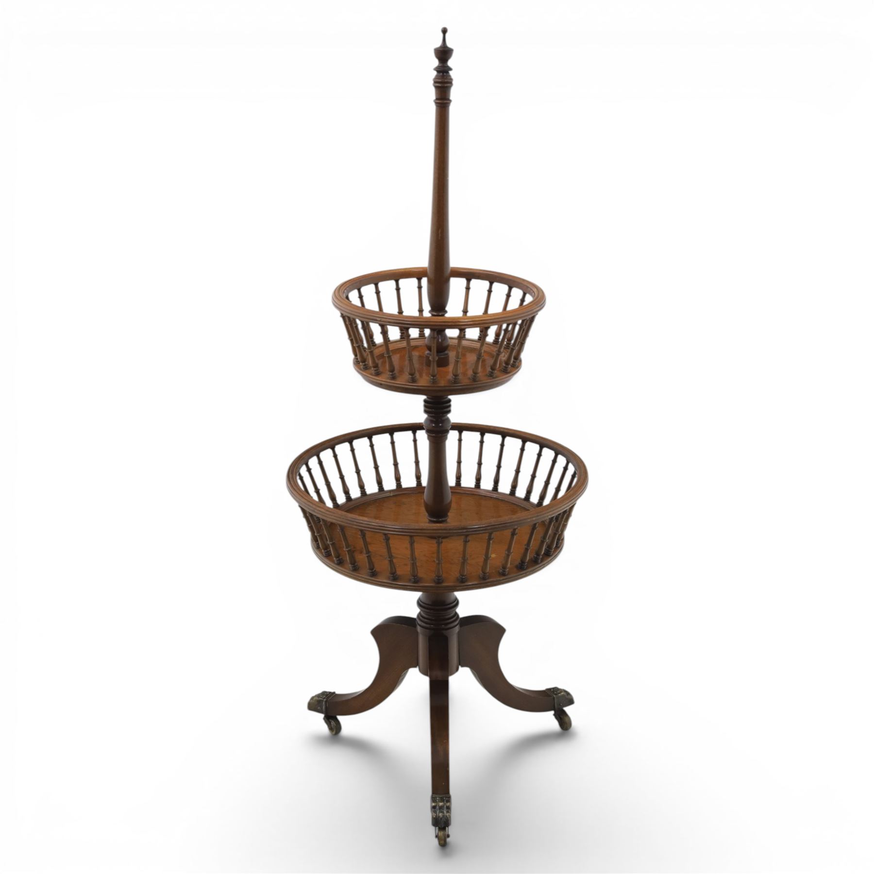 Regency style oak two-tier dumb waiter, with turned finial above central column support, two circular spindle-galleried basket tiers, raised on downswept tripod supports with brass caps and castors