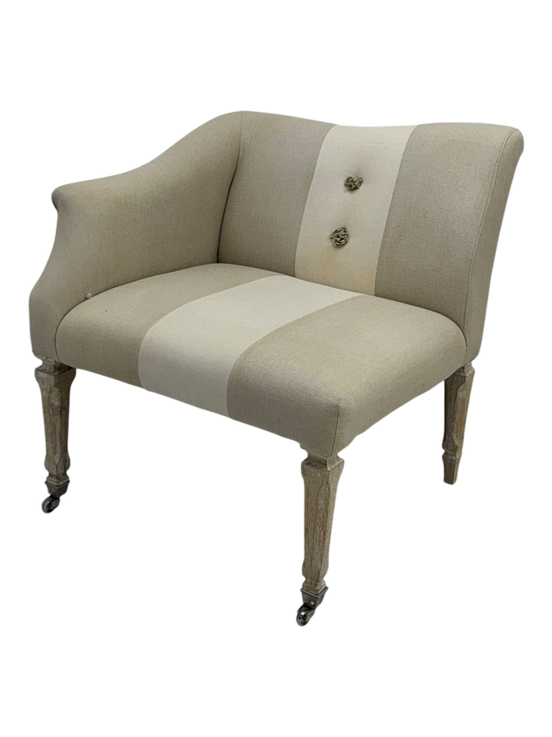 Pair of contemporary hardwood corner chairs, upholstered in broad alternating bands of neutral-toned fabric, each with two knotted rope buttons to the backrest, the whole raised on turned and lightly whitewashed supports terminating in castors