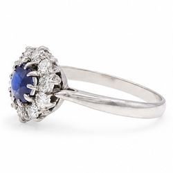 Platinum sapphire and diamond cluster ring, single round cut sapphire of approx 0.85 carat, surrounded by ten round cut diamonds, total diamond weight approx 0.40 carat