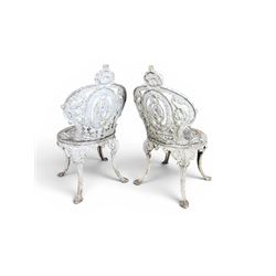 Pair of white painted cast metal garden chairs, ornate reclined backs, circular pierced seats on cabriole legs