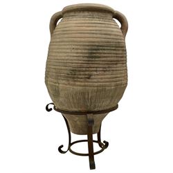 Large terracotta olive pot, ovoid belly amphora shape with twin carrying handles, on wrought metal base with scrolled supports