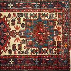 Caucasian Shirvan hand-knotted runner, ivory field decorated with a vertical sequence of bold hexagonal and lozenge medallions, each enclosing stylized geometric motifs, flanked by angular floral latch-hook devices, field dominated by madder red  and ivory with subsidiary colours of indigo, brown, and turquoise, with fringe ends   