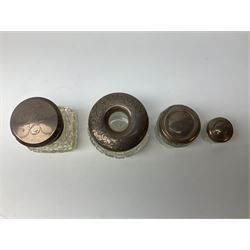 Hallmarked silver top dressing table jars, to include cut glass hobnail example with foliate engraved lid, another 20th century cut glass example with silver engraved screw thread lid, stamped H.S.M Herbert Scott Murdoch, with interior stopper and two smaller glass jars (4)