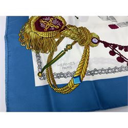 Hermès 'Le Timbalier' silk scarf, designed by Francoise Heron in 1961, printed with a central image of a gentleman on horseback donning extravagant dress, on white ground surrounded with colourful stylised knotted ropes, contained within peacock blue border, with rolled hand stitched edges and Hermes material label, 87cm square