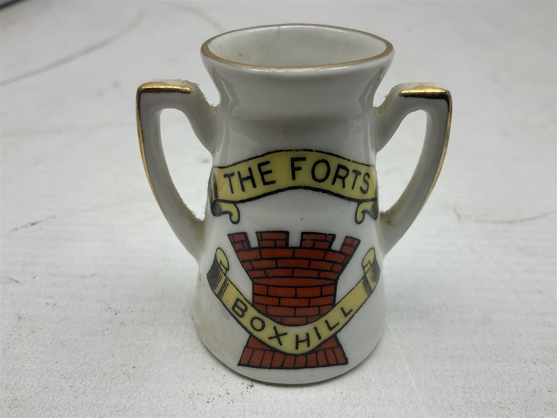 Twelve crested china models of WW1 tanks by Grafton, Arcadian and Carlton china etc with crests from Caistor Lincs, Saffron Walden, Paignton, Evesham etc  , together with a crested china model of the R.M.S Lusitania with New Brighton crest and a two-handled vase for 'The Forts Boxhill' (14)