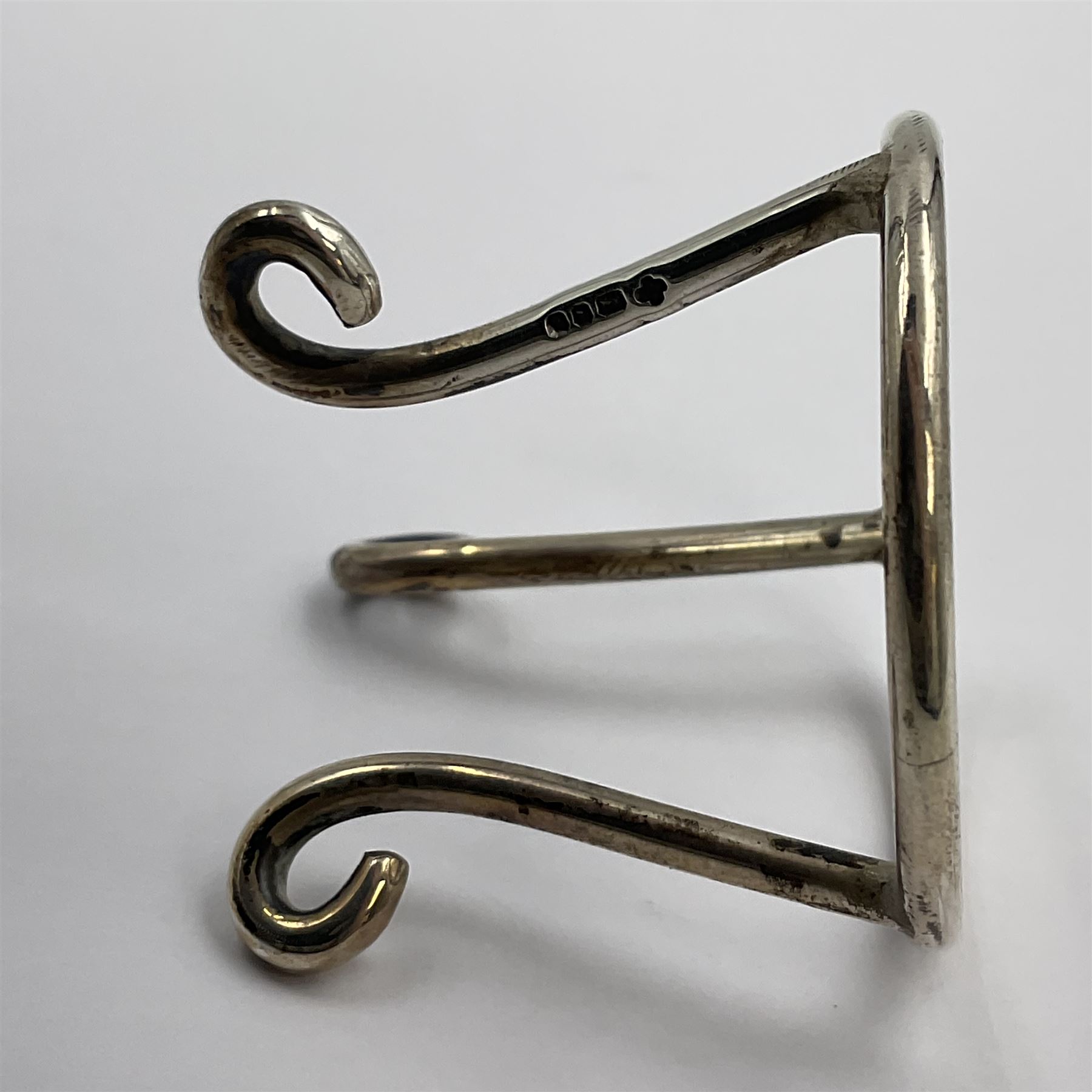 Modern silver limited edition Easter egg, no. 70/500, the gilt openwork body decorated with daffodils and detachable cover with pierced circular panel set with a single faceted blue stone, opening to reveal a gilt interior, upon silver stand with three scrolling pad feet, each hallmarked St James House Company, London 1980, height including stand 8cm