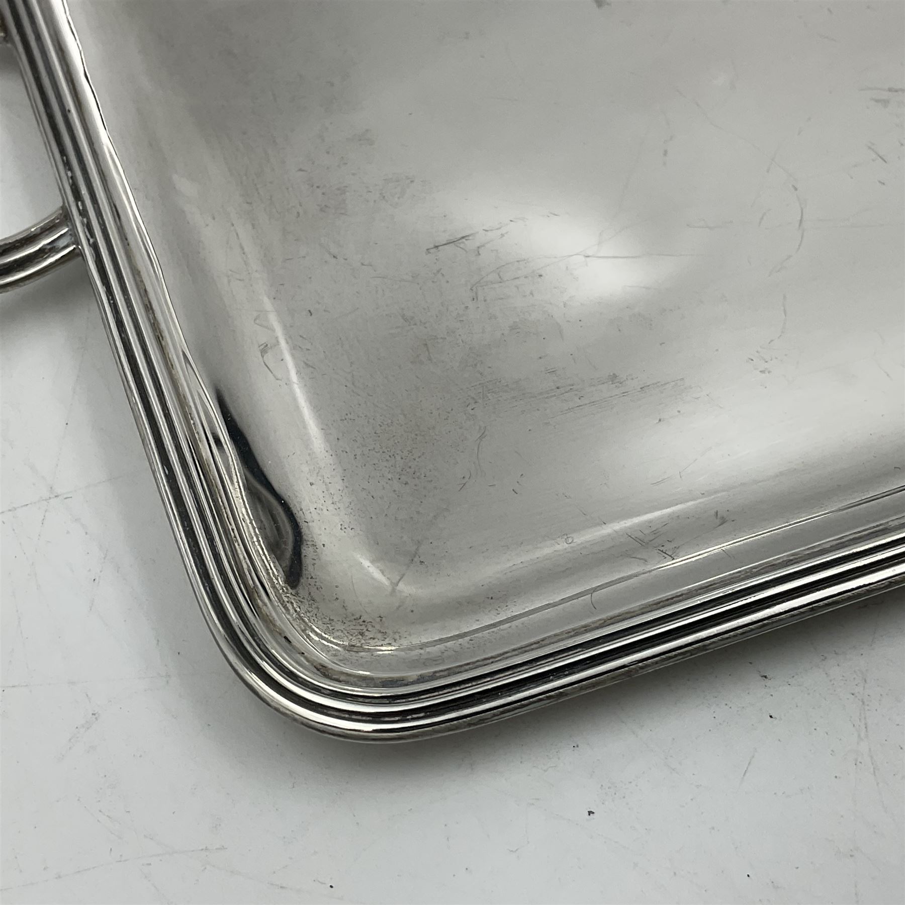 Small early 20th century silver tray, of rectangular form with reeded edge and twin reeded handles, hallmarked Asprey & Co Ltd, London 1914, including handles W26.5cm