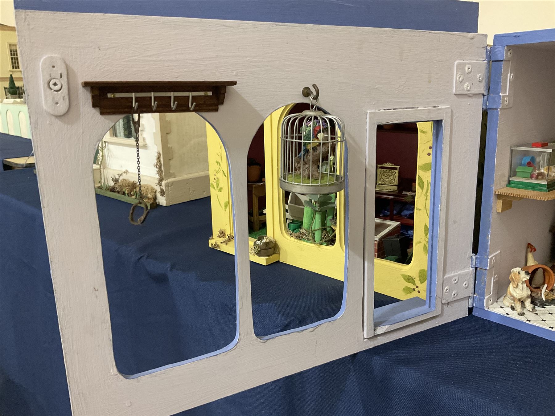 Three scratch-built wooden shop dioramas - single room Pet Shop with hinged front, fully furnished and well stocked with animals, birds and numerous accessories; and matching Garden Shop, fully furnished and well stocked with fruit, vegetables and garden accessories including lawn mower, wheelbarrows etc; each W34cm H27cm D26cm; and double fronted single room Butchers Shop with butcher at his block, partially stocked counter and two delivery cycles W57cm (3)