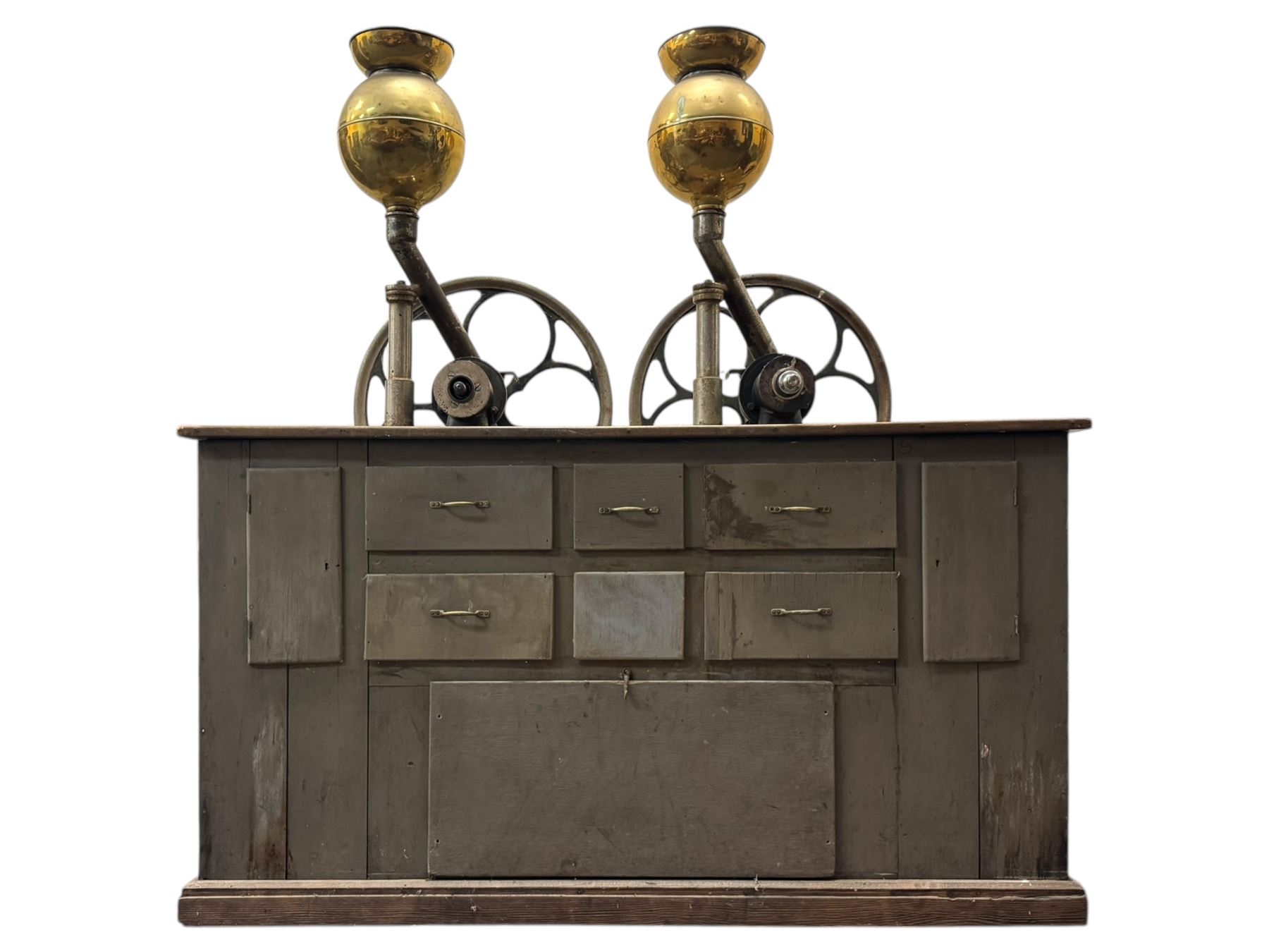 Cabinet with multiple drawers and cupboards mounted with two industrial coffee grinders with large flywheels and brass coffee reservoirs, early 20th century 