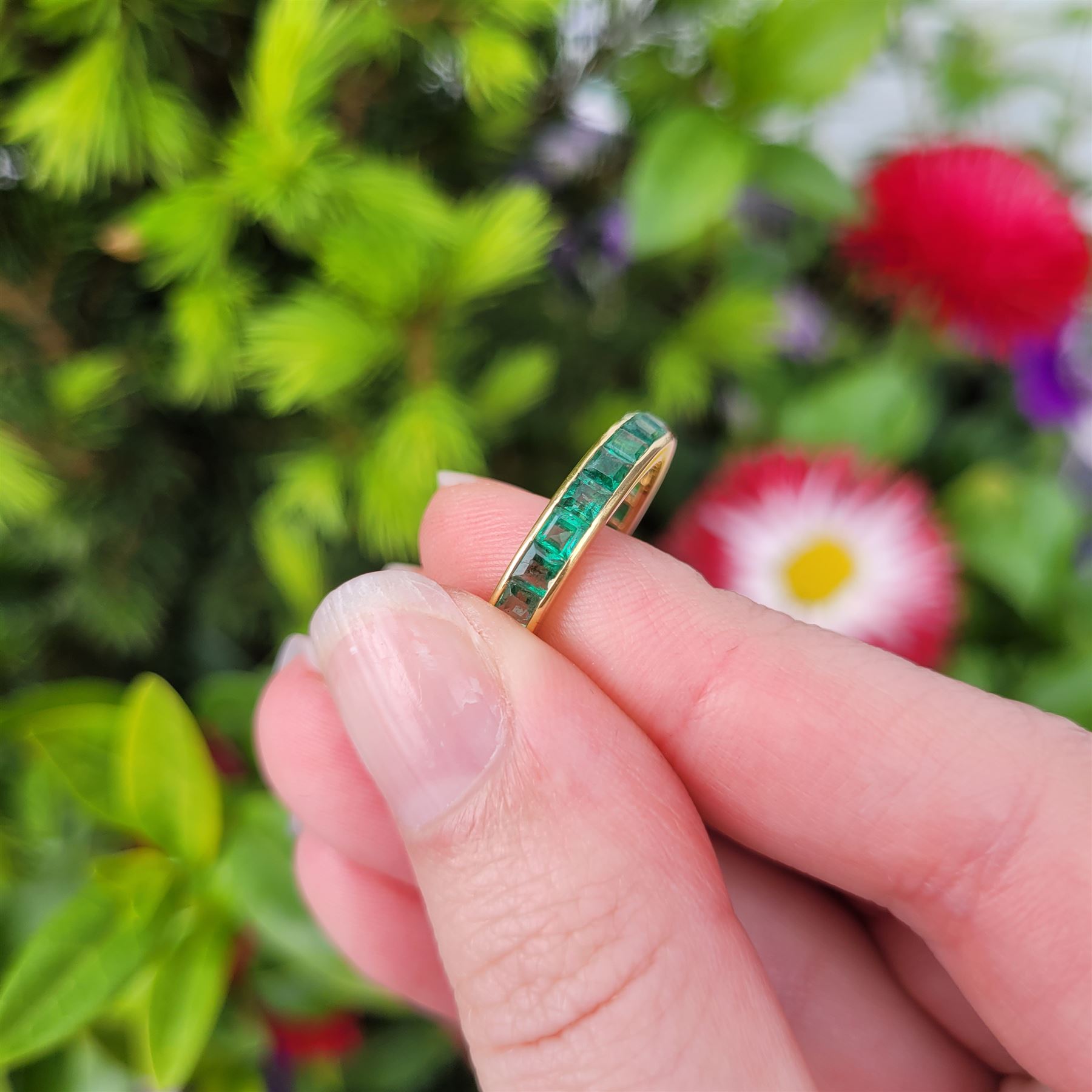 18ct gold emerald full eternity ring, channel set with calibre cut emeralds