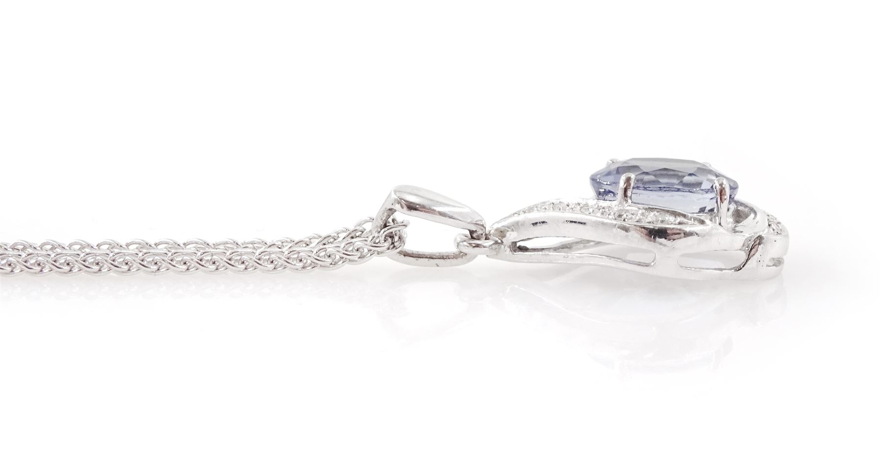 18ct white gold tanzanite and diamond pendant necklace, single oval cut light blue tanzanite of approx 3.25 carat, with diamond chip surround, on a wheat link chain necklace, both hallmarked