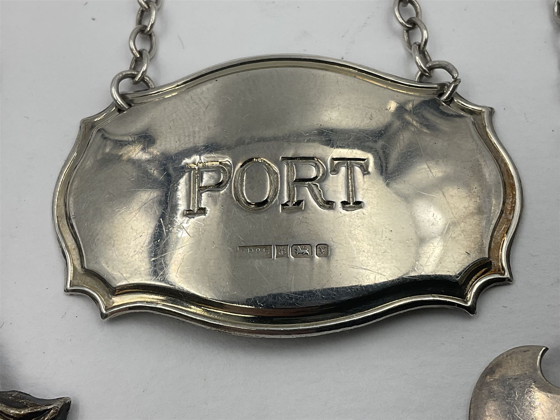 Five modern silver decanter labels, to include two sherry examples, embossed with scrolls and fruits, hallmarked W I Broadway & Co, Birmingham 1991 & 1997, a similar claret example, hallmarked S J Rose & Son, Birmingham 1973, and two plain shaped port and burgundy examples, hallmarked C Robathan & Son, Birmingham 1997 and A Haviland-Nye, London 1968
