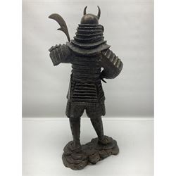 Bronze figure of a samurai standing wearing armour and holding a naginata, upon a rocky base, H48cm