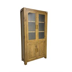 Tall oak cabinet, fitted with two glazed doors over two panelled cupboards, on square feet