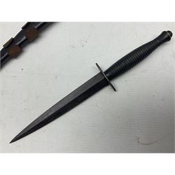 Third Pattern Commando Knife or Dagger with 17.5cm flattened diamond section blade and regulation black painted ribbed copper hilt with brass pommel nut; stamped William Rodgers Sheffield England to the cross-piece; in black painted brass mounted leather scabbard L34.5cm overall