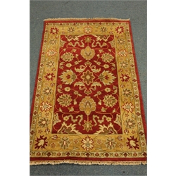  Indian woollen rug, red ground with gold floral decoration and border, 187cm x 121cm  