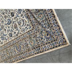 Large Fine Kashan carpet, ivory ground with interacting foliate designs and decorated with stylised flower heads, the multiple banded border decorated with scrolling foliage design with matching stylised flower heads, the outer guard signed by the weaver