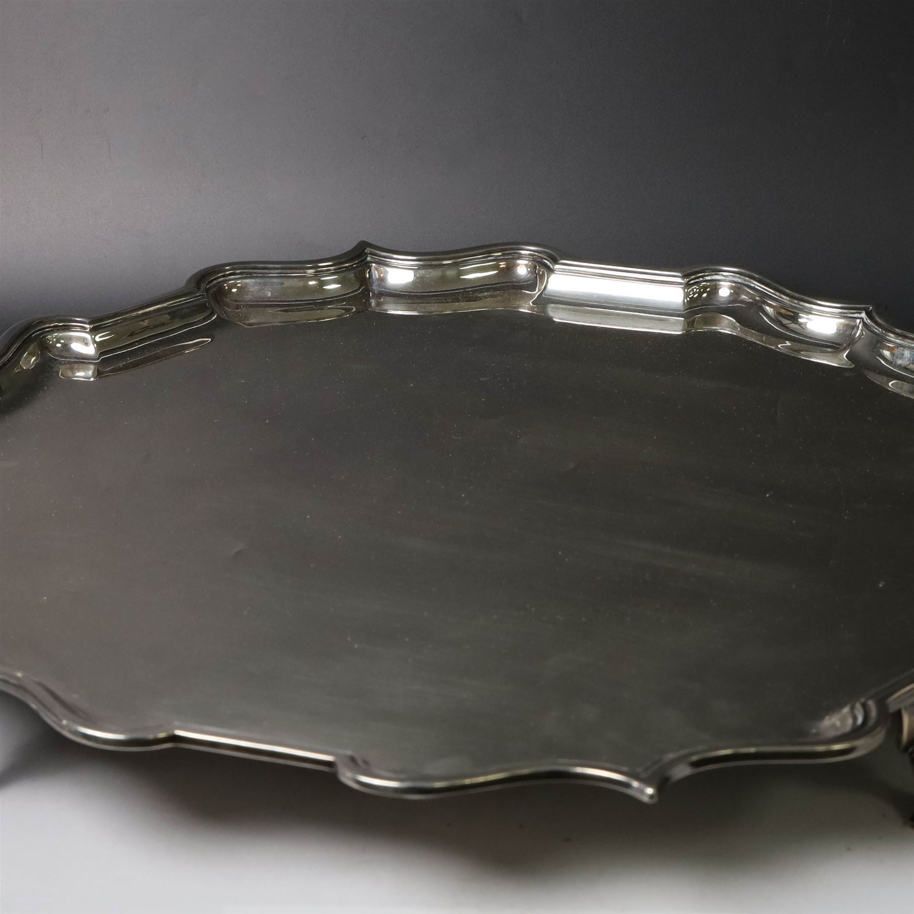 Early 20th century large silver salver, of circular form with Chippendale style rim, upon four hoof feet, hallmarked Elkington & Co Ltd, Birmingham 1918, D47cm